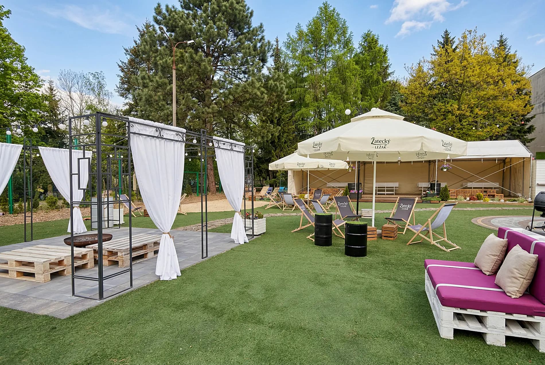 Strefa relaksu na świeżym powietrzu — meble z palet, parasole i leżaki w parku