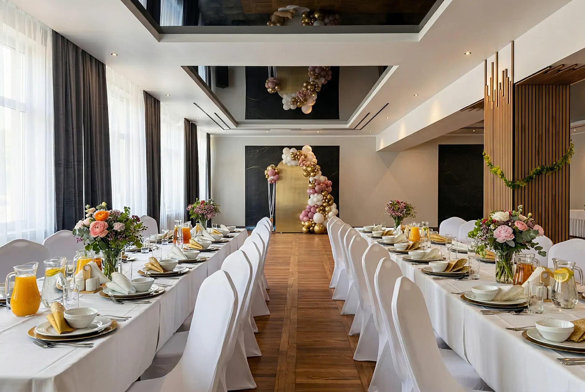 Elegancka sala bankietowa — długie stoły z kwiatowymi dekoracjami, lustrzany sufit i nowoczesne oświetlenie